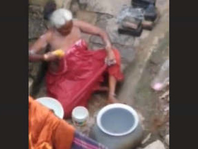 Elderly woman bathes outdoors
