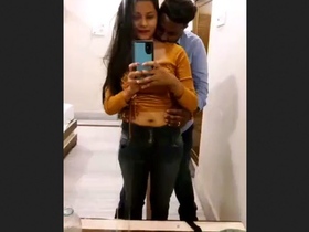 A loving couple explores each other's bodies in front of a hotel mirror