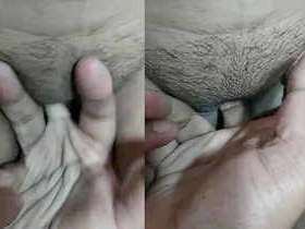 A South Asian man stimulates his partner's moist vagina with his fingers, causing her to vocalize pleasure