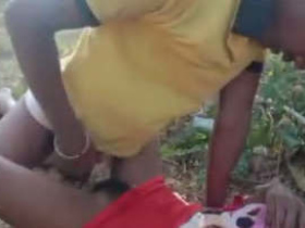 A rural woman engages in sexual activity in the wilderness, captured on camera by her companion
