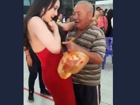 Elderly gentleman publicly fondling model's breasts