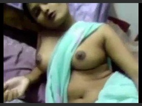 A South Asian wife undresses and touches her large breasts through a sari
